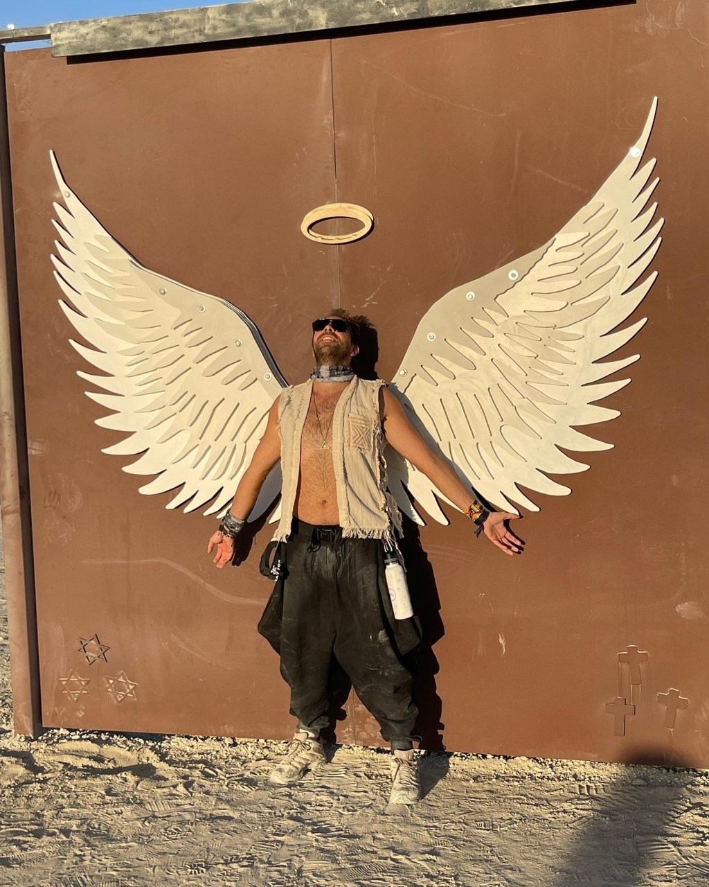 Olivier Grinda in front of an angel wings art installation in the desert